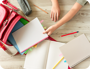 日本の小学生が学校かばんにノートや教科書を入れる様子