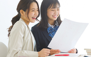 塾でテストの結果を喜ぶ女子学生